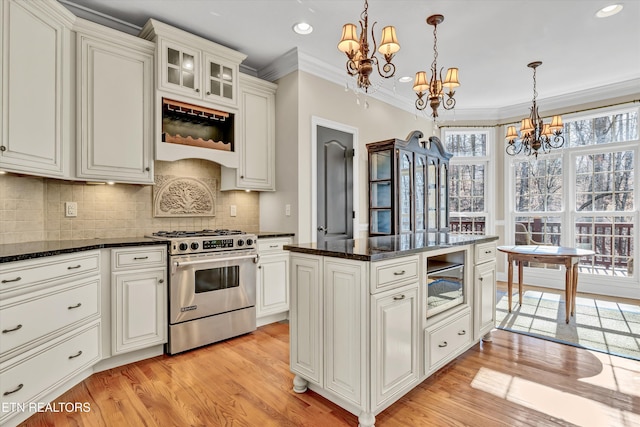 kitchen with crown molding, appliances with stainless steel finishes, decorative light fixtures, and a chandelier