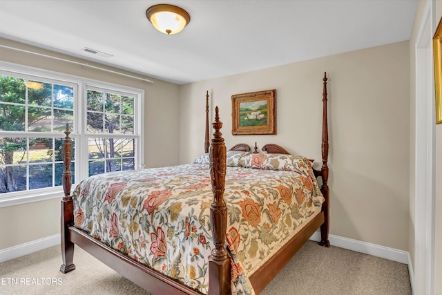 bedroom featuring light colored carpet and multiple windows