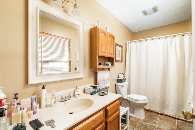 bathroom featuring vanity, walk in shower, a textured ceiling, and toilet