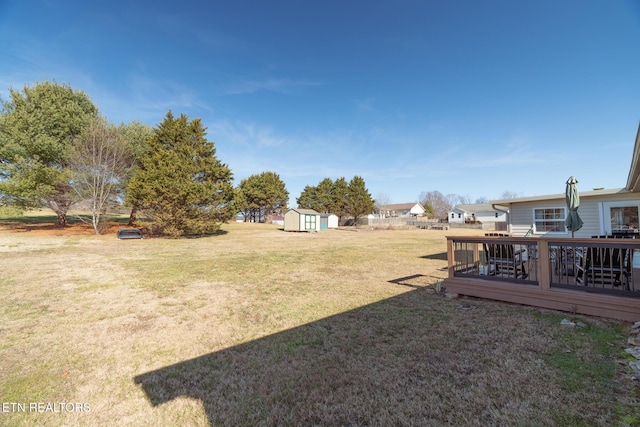 view of yard featuring a wooden deck and a shed