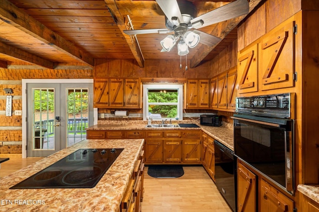 kitchen featuring wood walls, black appliances, light stone counters, wood ceiling, and light wood-type flooring