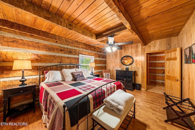 bedroom with beam ceiling, wooden ceiling, wood walls, and light wood-type flooring