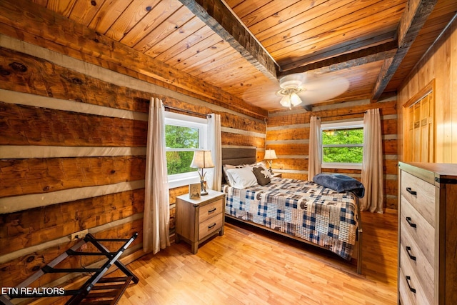 bedroom featuring multiple windows, light hardwood / wood-style flooring, wooden ceiling, and wood walls