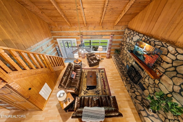 unfurnished living room featuring beamed ceiling, wood walls, wood-type flooring, and wooden ceiling