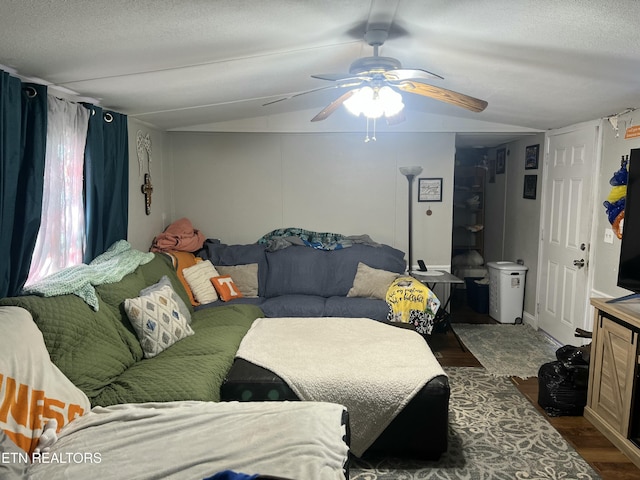 bedroom featuring dark wood-type flooring, ceiling fan, vaulted ceiling, and a textured ceiling