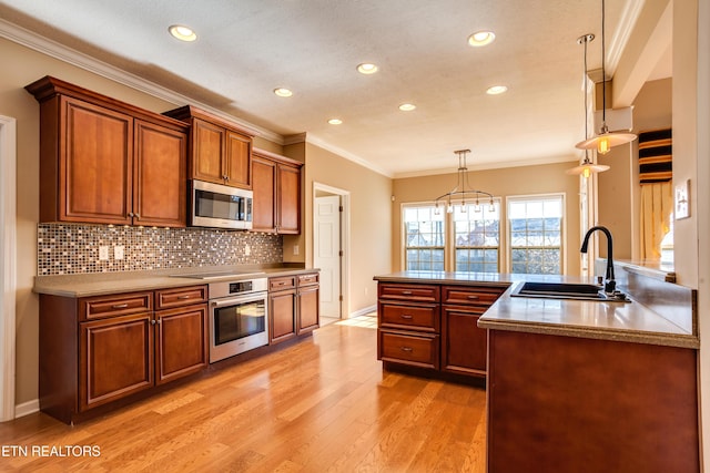 kitchen featuring sink, tasteful backsplash, light hardwood / wood-style flooring, pendant lighting, and stainless steel appliances