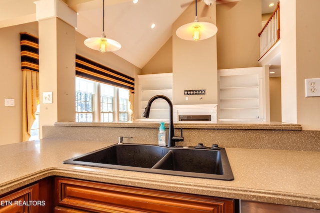 kitchen featuring high vaulted ceiling, sink, and hanging light fixtures