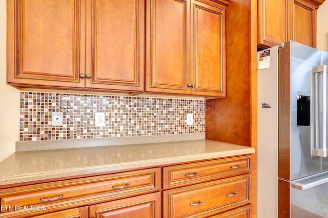 kitchen featuring high end refrigerator and backsplash