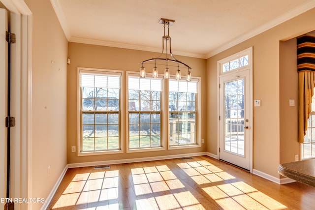 doorway to outside featuring ornamental molding and light wood-type flooring