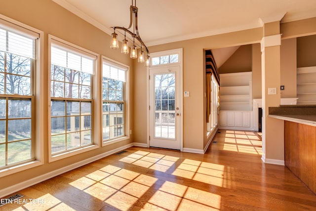 entryway with crown molding, built in features, and light hardwood / wood-style floors