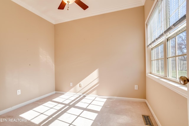 spare room featuring ornamental molding, light colored carpet, and ceiling fan