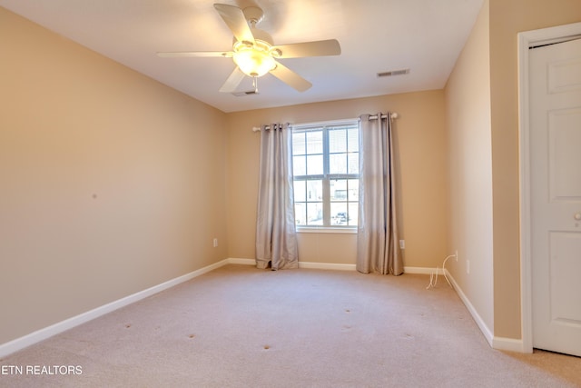 spare room with light colored carpet and ceiling fan