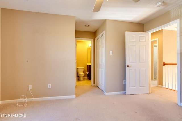 unfurnished bedroom with light carpet, connected bathroom, and ceiling fan