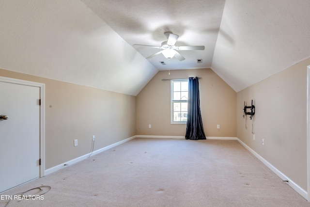 bonus room featuring ceiling fan, lofted ceiling, light carpet, and a textured ceiling