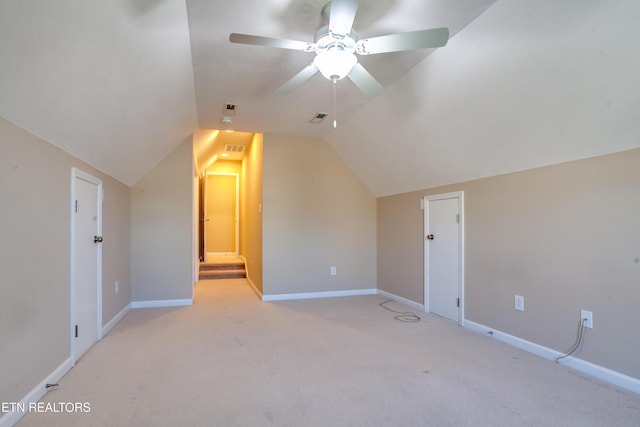 additional living space with ceiling fan, light colored carpet, and vaulted ceiling