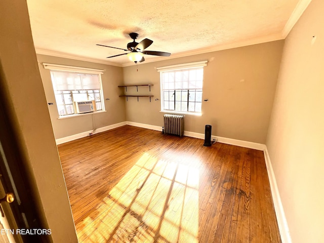 empty room with radiator, crown molding, hardwood / wood-style floors, and a textured ceiling