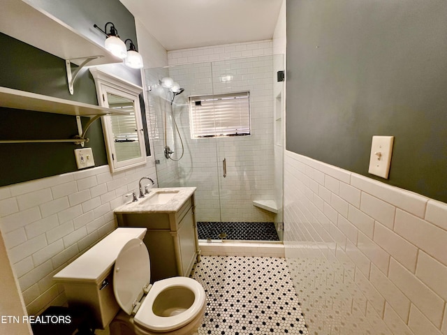 bathroom with vanity, toilet, tile walls, and walk in shower