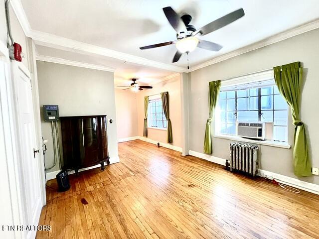 interior space with wood-type flooring, radiator heating unit, and crown molding