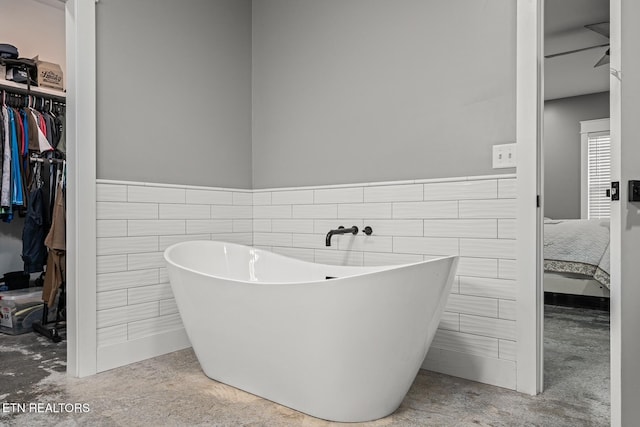 bathroom featuring tile walls and a bathtub