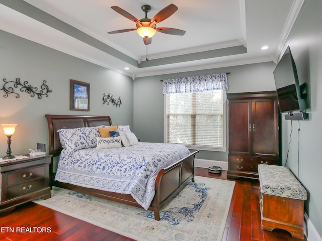 bedroom with a raised ceiling, crown molding, ceiling fan, and dark hardwood / wood-style flooring