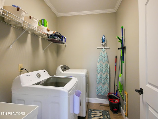 clothes washing area featuring tile patterned flooring, crown molding, washer and dryer, and sink