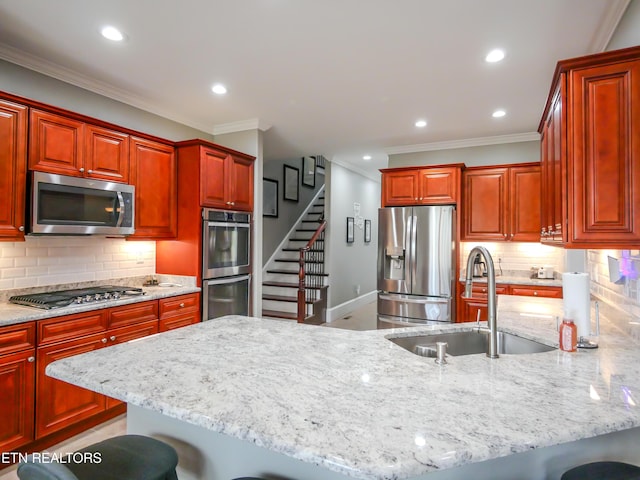 kitchen with light stone counters, stainless steel appliances, sink, and a breakfast bar area