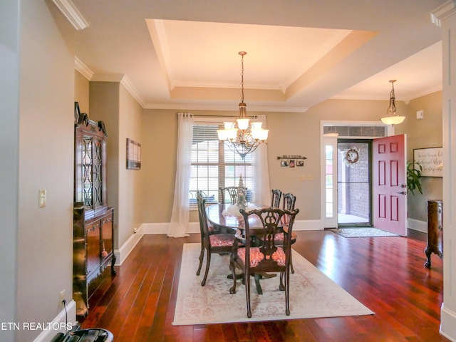 dining room featuring crown molding, a tray ceiling, and dark hardwood / wood-style flooring