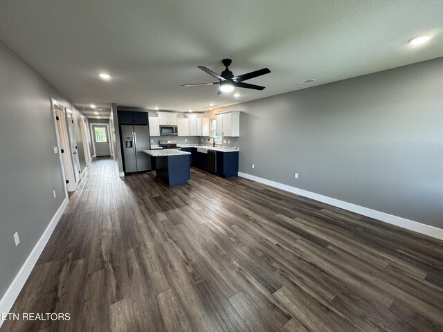 453 N Main St, Oneida, TN 37841 - kitchen with a kitchen island, light countertops, open floor plan, stainless steel appliances, and dark wood-type flooring
