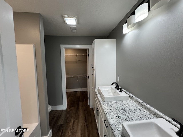 453 N Main St, Oneida, TN 37841 - full bath featuring visible vents, wood finished floors, toilet, baseboards, and a walk in closet
