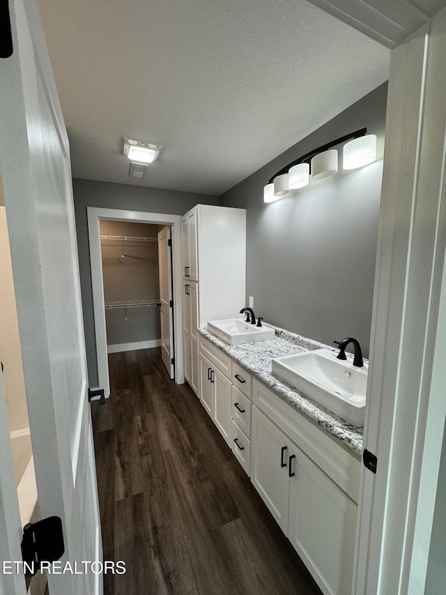 453 N Main St, Oneida, TN 37841 - bathroom featuring a sink, double vanity, wood finished floors, and a spacious closet