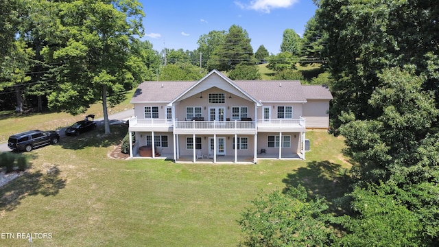 back of property featuring a wooden deck, a lawn, and a patio