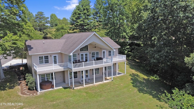 rear view of property featuring a yard, a deck, and a patio area