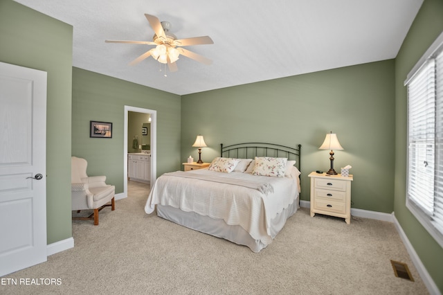 carpeted bedroom featuring ceiling fan and ensuite bath