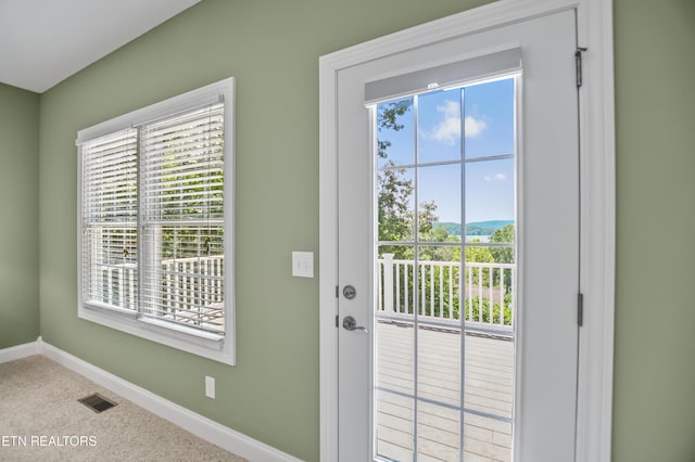 doorway to outside featuring a healthy amount of sunlight and carpet floors