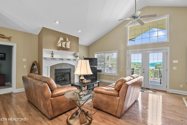 living room with a tiled fireplace, light hardwood / wood-style floors, and a healthy amount of sunlight