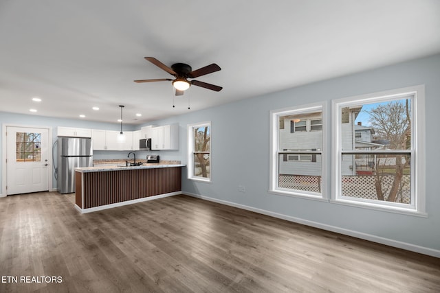 kitchen with sink, stainless steel appliances, light hardwood / wood-style floors, and white cabinets