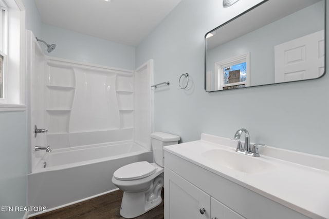 full bathroom featuring hardwood / wood-style flooring, vanity, toilet, and bathing tub / shower combination