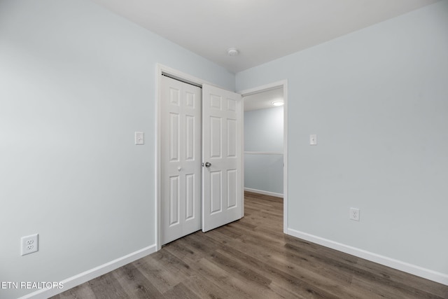 unfurnished bedroom with hardwood / wood-style flooring and a closet