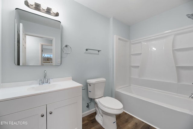 full bathroom featuring vanity, hardwood / wood-style flooring, bathtub / shower combination, and toilet