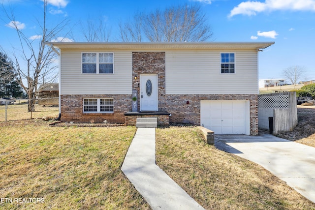 split foyer home featuring a garage and a front lawn