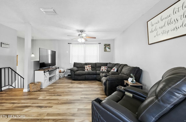 living room featuring ceiling fan and light hardwood / wood-style flooring