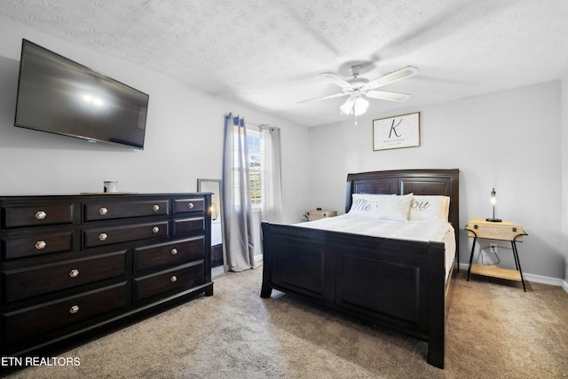 carpeted bedroom with ceiling fan and a textured ceiling