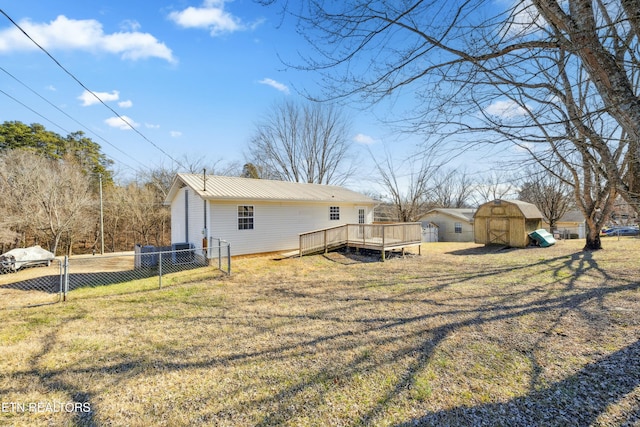 exterior space with a shed, a yard, and a deck