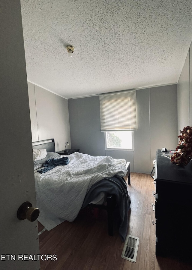 bedroom featuring a textured ceiling and light wood-type flooring