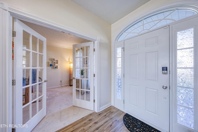 entrance foyer with plenty of natural light, a textured ceiling, and french doors