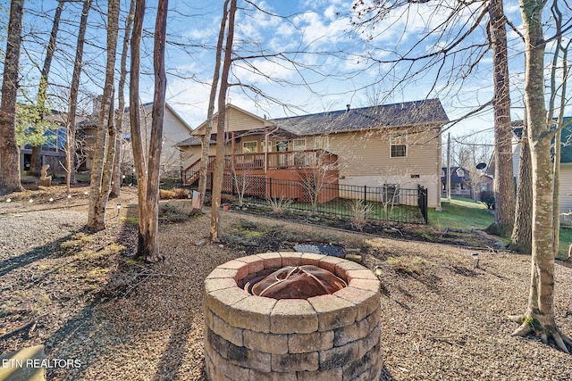 rear view of house with a wooden deck and a fire pit