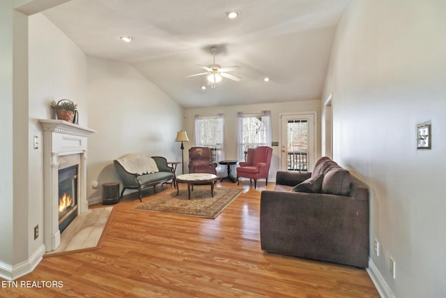 living room featuring vaulted ceiling, ceiling fan, and light wood-type flooring