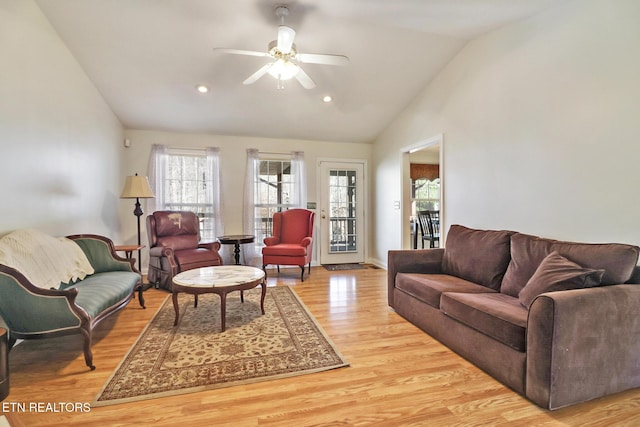 living room with ceiling fan, lofted ceiling, and light wood-type flooring