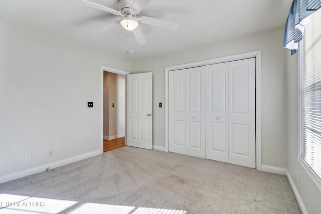 unfurnished bedroom featuring ceiling fan, light colored carpet, and a closet