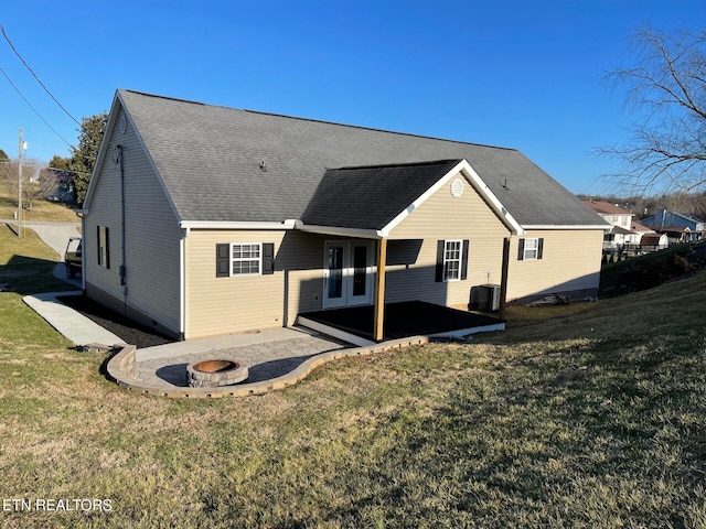 rear view of house with a patio, an outdoor fire pit, a yard, central air condition unit, and french doors